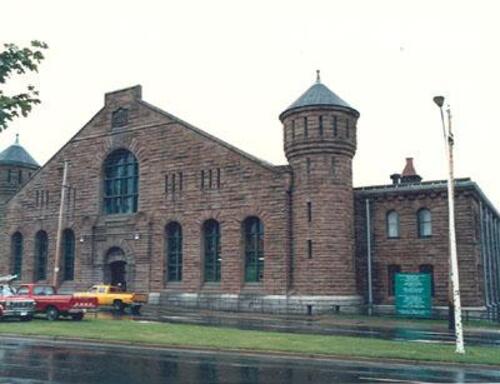 Corner view of a façade of Halifax Drill Hall, showing the entrance, 1990.; Department of National Defence/ Ministère de la Défence nationale, 1990.