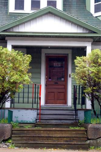 This image shows the entrance portico with pediment and wood-panelled door with light; City of Saint John