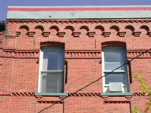 This photograph shows the band of blind Roman arches at the roof-line.  It also shows the windows and the brick courses, 2007; City of Saint John