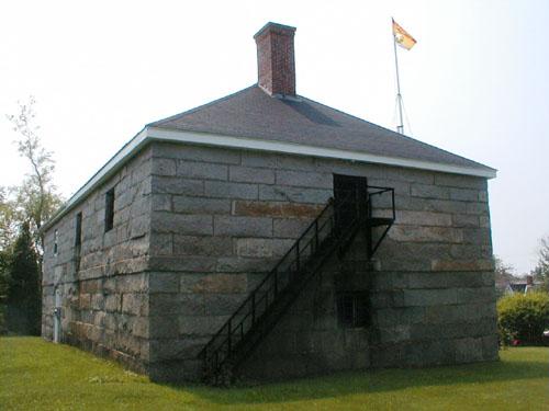 This side elevation includes a metal stairway leading to a door on the second level of the building.; PNB 2004