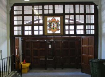 Interior view of the armoury, showing the early heraldic boar crest of the regiment above the door, 2006.; R. Goodspeed, 2006.