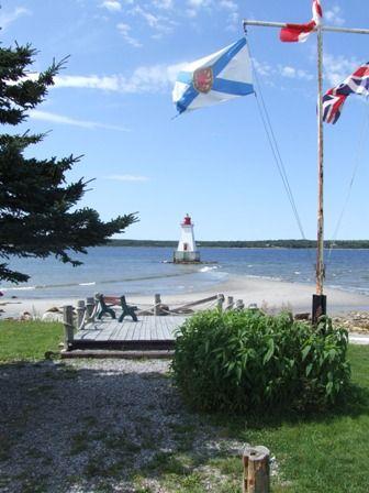 The picturesque view of Sandy Point Lighthouse from the shore of Shelburne Harbour, Nova Scotia.; Heritage Property Program, Nova Scotia Heritage Division, 2009