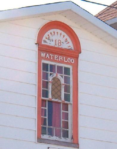 Exterior view of a coloured glass window on the main facade of Waterloo Loyal Orange Lodge No. 18, New Perlican, NL, Photo taken 2006. ; HFNL/Lara Maynard 2006
