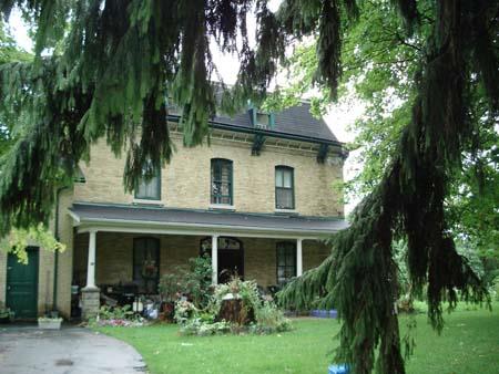 Featured is the buff-brick two-storey façade of the residence, including the projecting veranda.; Martina Braunstein, 2007.