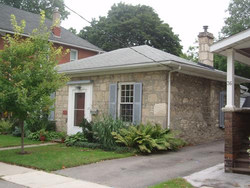 Of note is the hipped roof and stone chimney.; Paul Dubniak, 2008.