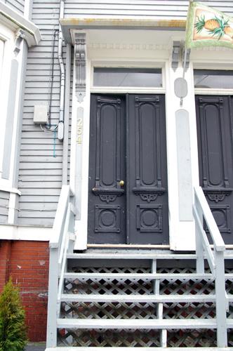 This image shows the paired entrances with transoms, shared entablatures and wooden paired doors; City of Saint John