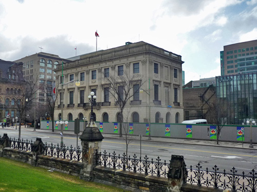 Corner view of the Former U.S. Embassy showing its cube-like massing, reflected in the rectilinear footprint, flat roof, and symmetrical composition centred on the main entrance of the principal elevation, 2011.; Parks Canada Agency / Agence Parcs Canada, M. Therrien, 2011.