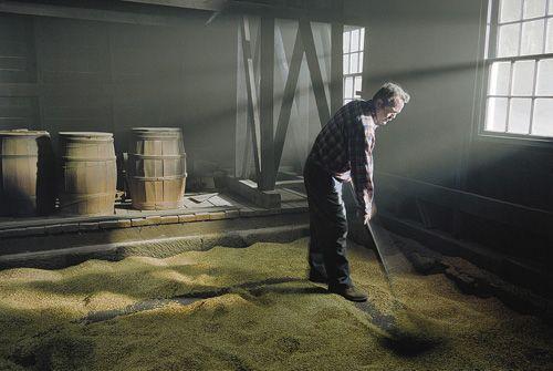 Miller turning oats in the kiln section of the mill. Balmoral Grist Mill, Balmoral Mills, NS, 2004.; Dept. of Tourism, Culture and Heritage, Province of NS, 2004.