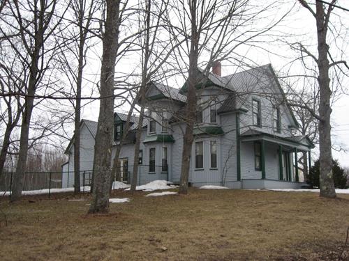 This image shows the overall view of the front and side façades of the residence; Village of Cambridge-Narrows