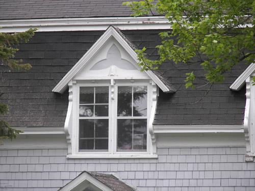 The central dormer of the front façade with vertical woodwork that serves as extended brackets; Bernard LeBlanc