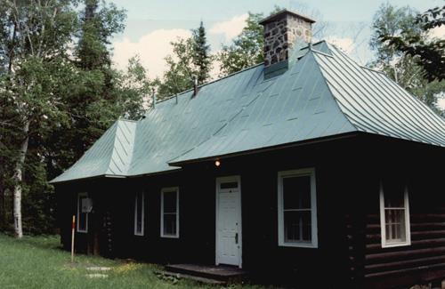 General view of Andrew Lodge, showing the central volume with a pitched roof and sloping dormer, and the two projecting wings with hip roofs, 1990.; Canadian Parks Services / Service canadien des parcs, 1990.