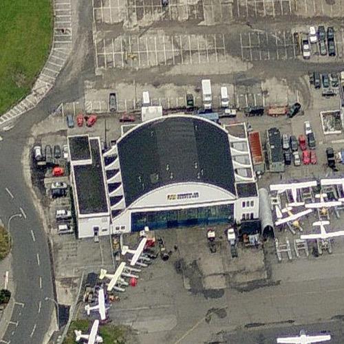 Arial view of the Harbour Air Hangar, Building T-018, showing the simplicity and asymmetry of the principal façade with its two-storey tower at the southwest corner featuring a flat roof and balanced punctuation of narrow vertical windows, 2011.; Microsoft Bing Maps, 2011.