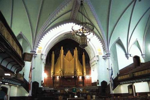 View of the interior of St. James United Church emphasizing the surviving original interior features at the north end of the sanctuary which typify Methodist churches of the period, including the communion rail, the pulpit platform, the pews for the choir; Parks Canada Agency / Agence Parcs Canada, D. Stiebeling