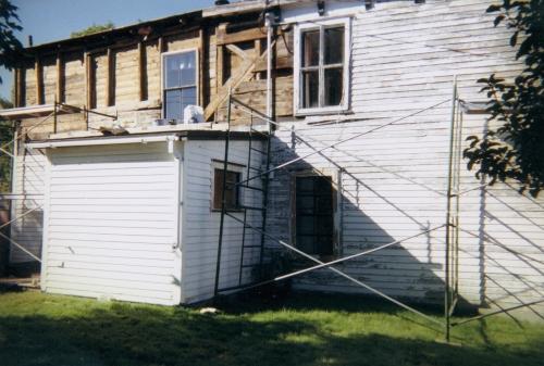 East wall being stripped of clapboard and sheathing in 1999. East, north and south walls have been reframed, resheathed and insulated. These three sides also have new windows, doors, clapboard and replicated eaves brackets.  Photo taken 1999.; Steve O'Driscoll 2010