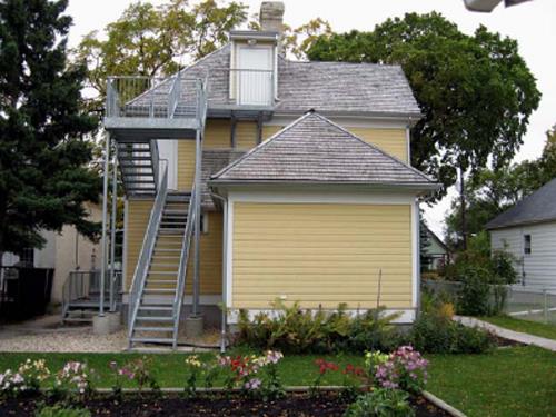 General view of the rear of the Maison Gabrielle-Roy showing some of the landscaping features that date back to when the Roy family owned the house, including century-old trees, 2008.; Parks Canada Agency / Agence Parcs Canada, N. Clerk, 2008.