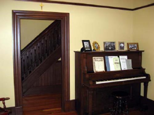 View of the interior of the Maison Gabrielle-Roy putting an emphasis on the extensive use of wood inside, including wood strip floors, wainscoting, large baseboards, picture rails, and door and window trim, 2008.; Parks Canada Agency / Agence Parcs Canada, N. Clerk, 2008.