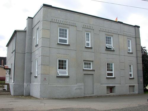 The image displays the corner pilasters, the cubic structure of the building as well as the minimal fenestration framed by simple geometric motifs.; PNB 2004