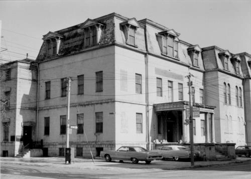 Corner view of the Bank of Upper Canada Building with its stone exterior, with rusticated masonry on the foundation and smooth-dressed stonework on the upper storeys, 1970s.; Parks Canada Agency / Agence Parcs Canada, 1970s.