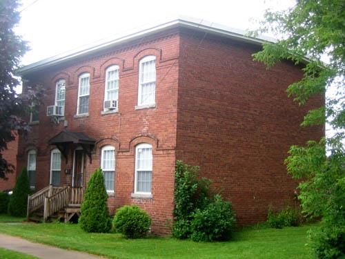 Image of brick tenement dwelling, side view, showing low-pitched roof.; City of Fredericton