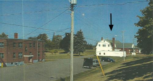 Panoramic view of the Cereal Forage Building (right) and Building 10 (left) showing the compatible scale, materials and style vis-a-vis the remaining adjacent buildings on the farm, 2001.; Agriculture and Agri-Business Canada \ Agriculture et Agroalimentaire Canada, 2001.