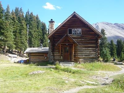 View of side elevation of Main Building depicting the massive stone chimney and projecting rear wing, viewed from east.; Agence Parcs Canada / Parks Canada Agency, ca./vers 2013.