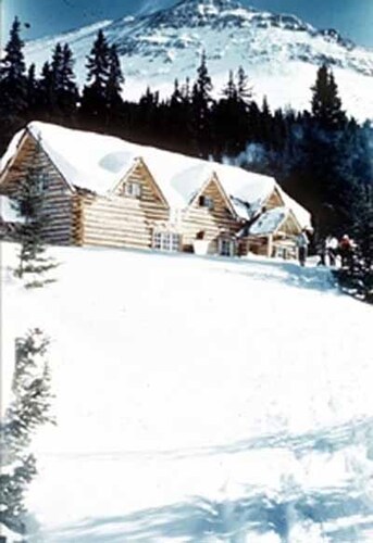 General view of the Skoki Ski Lodge showing its simple configuration, horizontal log construction with locally cut, unscribed, spruce logs, joined with saddle- or dovetail-notched corners, 1959.; Parks Canada | Parcs Canada, 1959