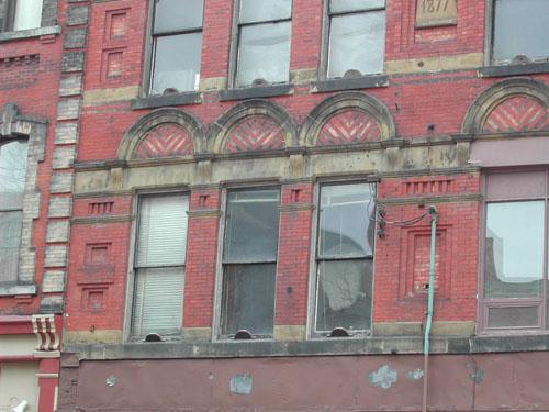 This photograph shows the arches over the second floor windows and the headers on the window sills.; City of Saint John