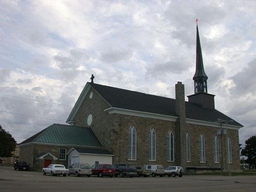 Rear view of the church showing a stone shelter at the side exterior door.; PNB 2004
