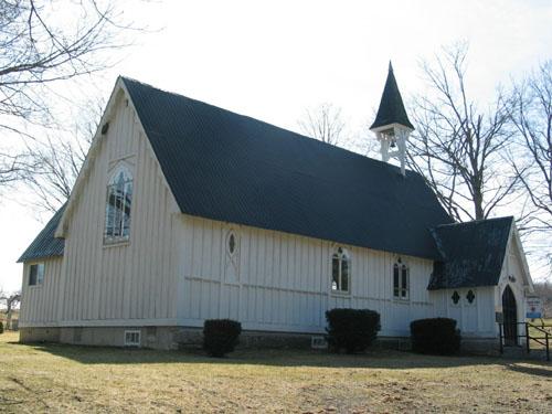 This image illustrates the small windows along the front facade and the ornate triple-lancet chancel window on the east side of the building.; PNB 2005