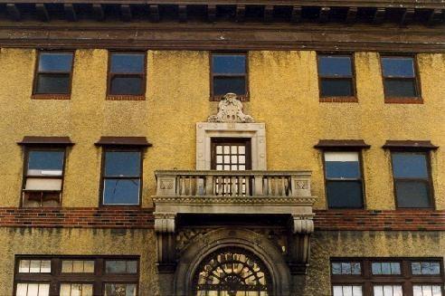 Central entry is accented with an elaborate, arched, cut stone surround and cantilevered balcony on the three-storey Italianate Romanesque - Renaissance Revival style building.; City of Windsor Collection