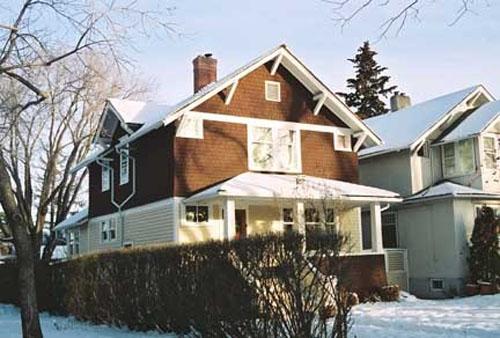 This image illustrates the two storey west and south wood-clad facades with  front and rear gables, side dormer, soffit support brackets, corner 'eye' windows and full-width hipped-roof veranda.; City of Edmonton