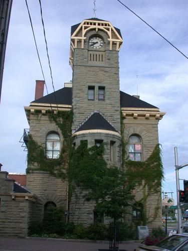 This image of the front façade illustrates the mansard roof of the building and the Italian bracket and hipped roof of the tower.; PNB 2005