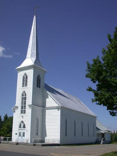 This image presents the front facade of the church and five pointed arch windows along the side of the building.; PNB 2005
