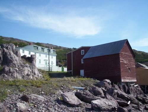 Exterior view of John Quinton Limited property, Red Cliffe, NL, taken from the waterside, showing (left to right) the shop, residence, fish store and salt store.; HFNL/Dale Jarvis 2006