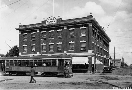 This historical image, dating from 1916, illustrates the front, west-facing primary facade of the building on 97th Street, an important arterial road connecting the McCauley neighbourhood with the downtown as evidenced by the streetcar line.; Glenbow Archives; McDermit Studio; NC-6-2382