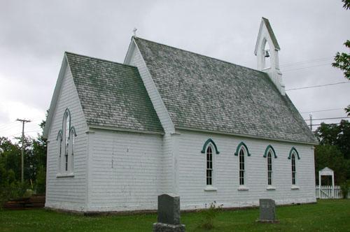 This image illustrates the high pitched roof capped on top by a delicate open bell-cote with arch enclosure and the four pointed slender single lancet windows on the north side of the building. ; PNB 2005