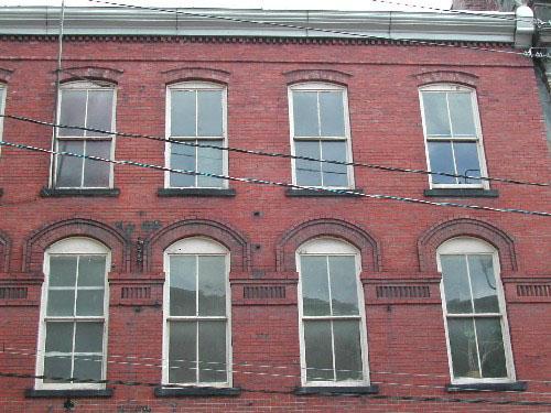 This photograph shows the window design, the ledge that runs through the second storey, and the roofline cornice, 2004; City of Saint John 
