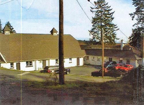 General view of the Cow Barn and Dairy showing its barn roofs with their wide eaves, exposed rafters, ventilation cupolas, external chimneys, and shed dormer windows, 2000.; Department of National Defence / Ministère de la Défense nationale, D. Cebula, 2000.