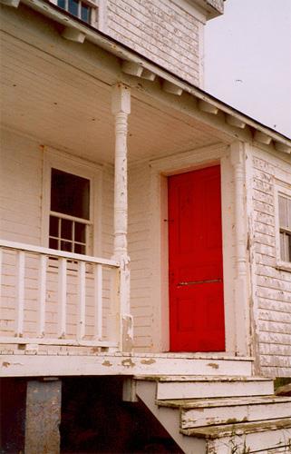 Detail view of the Rook Island Lighthouse's front verandah showing a modest attempt at exterior decoration, 2001.; Department of Fisheries & Oceans Canada/Département de pêches et océans Canada, 2001.