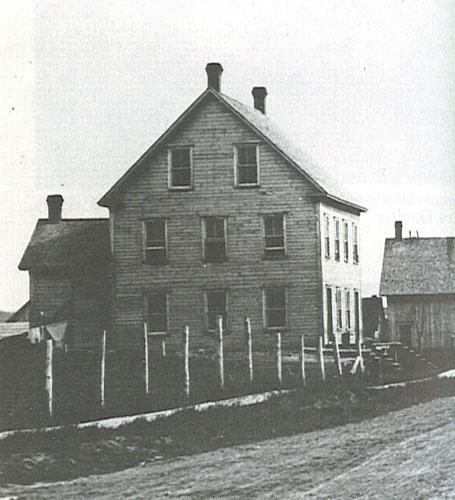 This historic photograph presents the two-and-a-half-storey wooden structure.; Village of Saint-Quentin