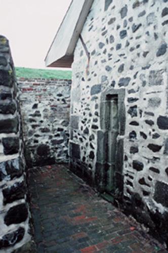 Detail view of the main entrance of the South Powder Magazine and the surrounding protective walls, 1994.; Parks Canada Agency / Agence Parcs Canada, Jérôme, J.P., 1994.