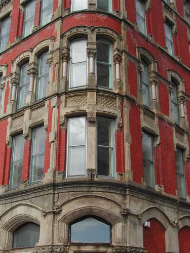 Photograph showing the windows and the columns that support the heavy segmented arches on the 3rd floor, 2004.; City of Saint John 
