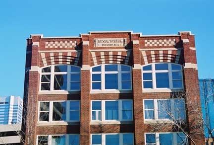 This  image illustrates, in detail, the decorative features of the upper part of the front facade, including the precast name plaque in the upper parapet of the HV Shaw Building.; City of Edmonton, 2004
