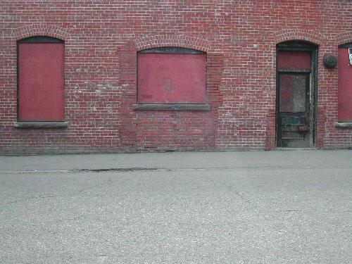 This photograph shows the entranceway and windows under flush segmented arches, 2004.; City of Saint John