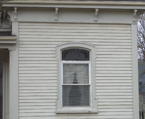 Architectural details:  decorative upper fanlight on window and under eave bracketing with pendants; City of Charlottetown, Natalie Munn, 2005