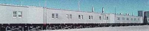 Side façade of Module Train A, showing its exterior metal cladding and the size, form and spacing of door and window openings dictated by each modules function, 1998.; (Canada, North Warning System Office / Bureau du système d'alerte du Nord , 1998.)