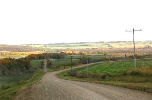 View south at site location on low ground, middle of frame, right of road, 2004.; Government of Saskatchewan, Marvin Thomas, 2004.