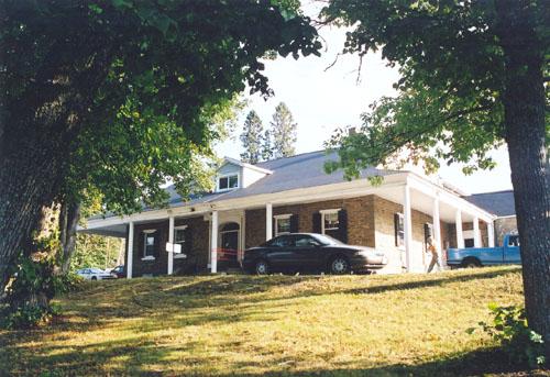 View of the large 1 1/2 storey Neoclassical Style sandstone house well positioned above a large expansive front lawn with mature trees.; PNB 2005