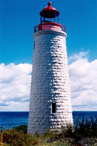 General view of the Griffith Island lighthouse showing its tall, round, slightly tapered form corbelled at the top to form a gallery and base for the lantern, 1990.; Canadian Coast Guard / Garde côtière canadienne, 1990.