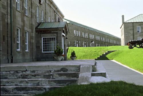 Side view of the Staff Headquarters of the Royal 22 Regiment, former Hospital, Building 1 showing the Neoclassical details of the main entrance to the building, 1993.; Parks Canada Agency / Agence Parcs Canada, C. Rodriguez, 1993.